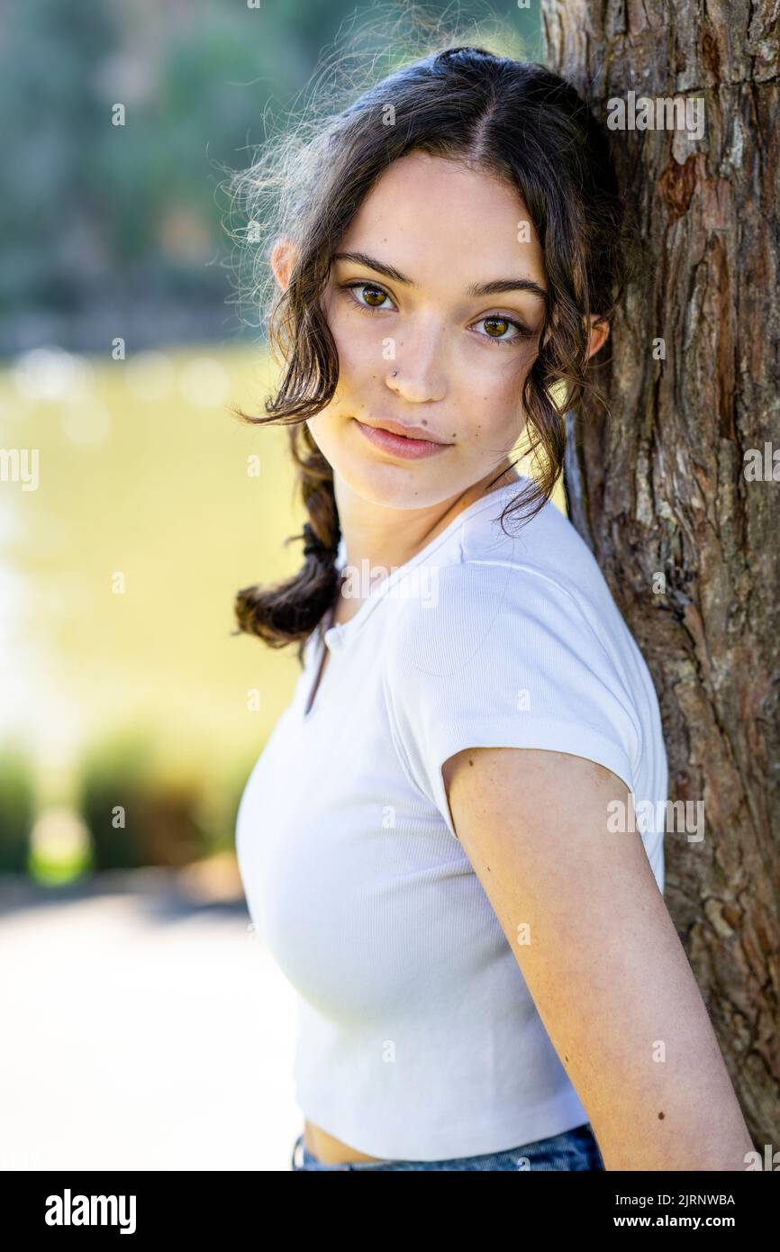 Close Up Portrait of a Young Woman Leaning on Tree with the Palace of Fine Arts in the Background Stock Photo