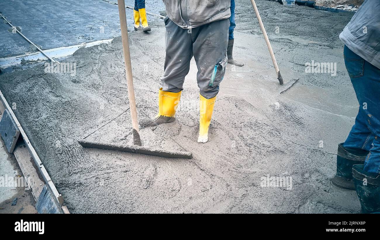 Contractors spread cement grout using trowel Stock Photo Alamy
