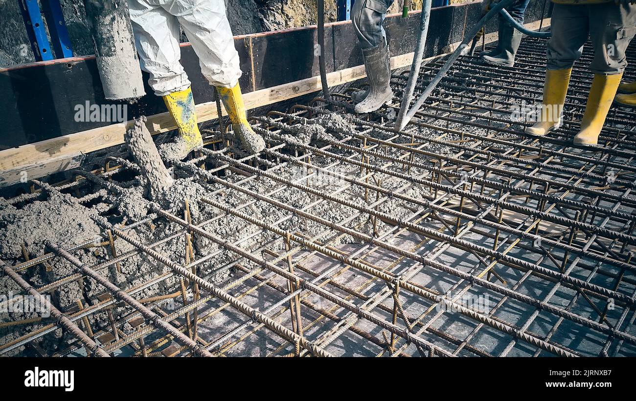 Construction workers are pouring concrete to formwork Stock Photo
