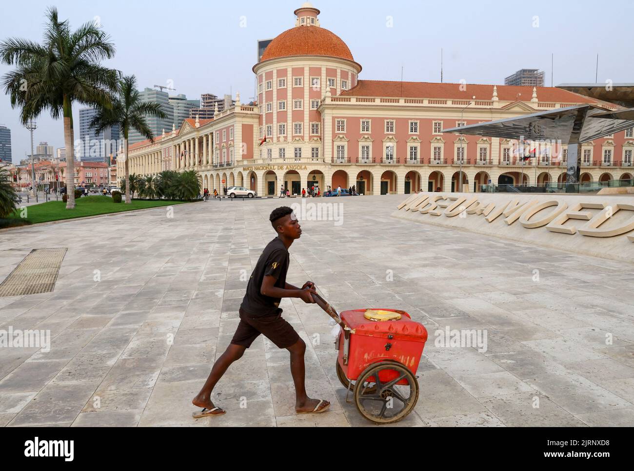 A boy pushes a trolley in front of the National Bank of Angola, in Luanda, Angola,  August 25, 2022. REUTERS/Siphiwe Sibeko Stock Photo