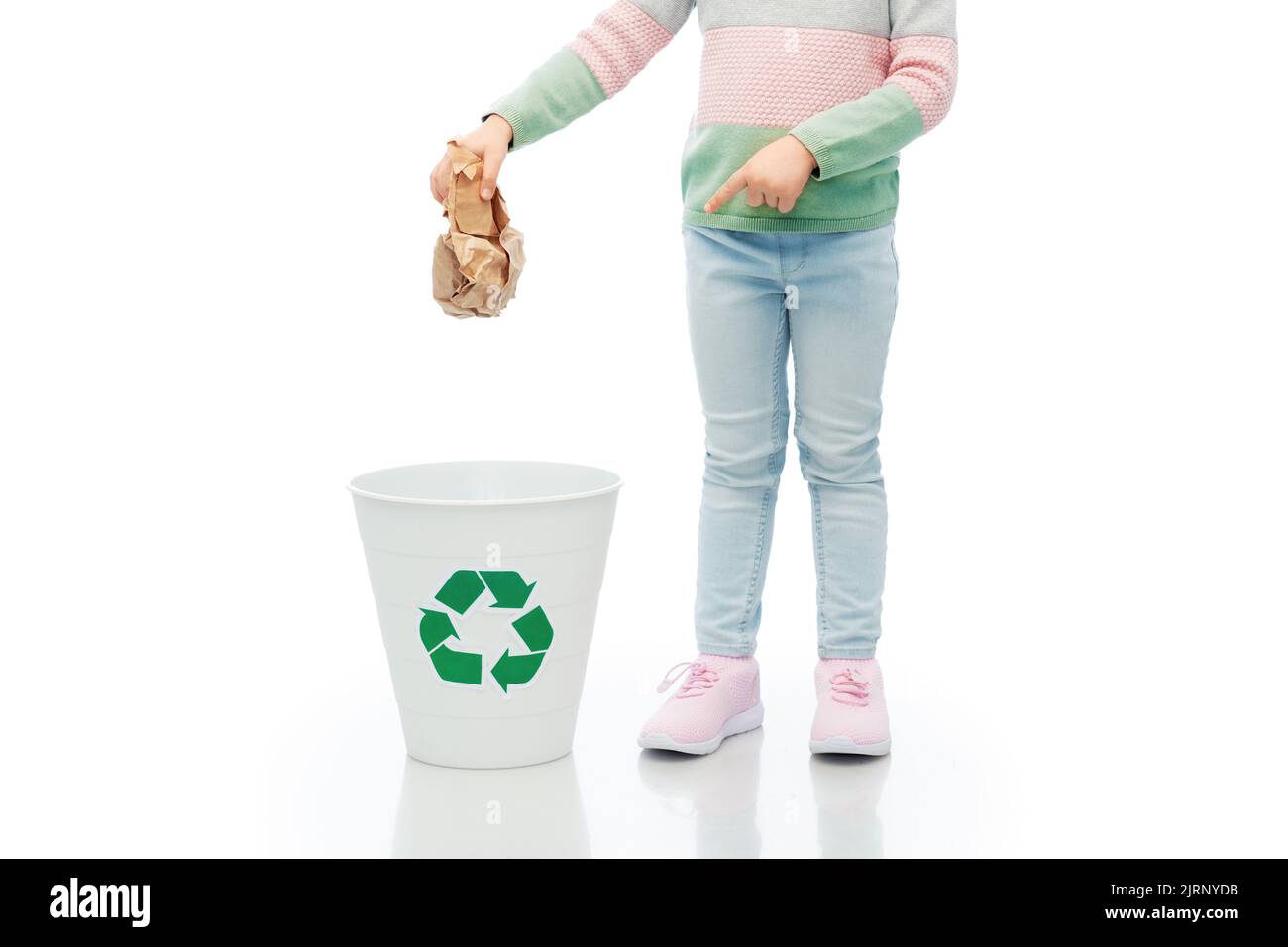 girl throwing paper waste into rubbish bin Stock Photo