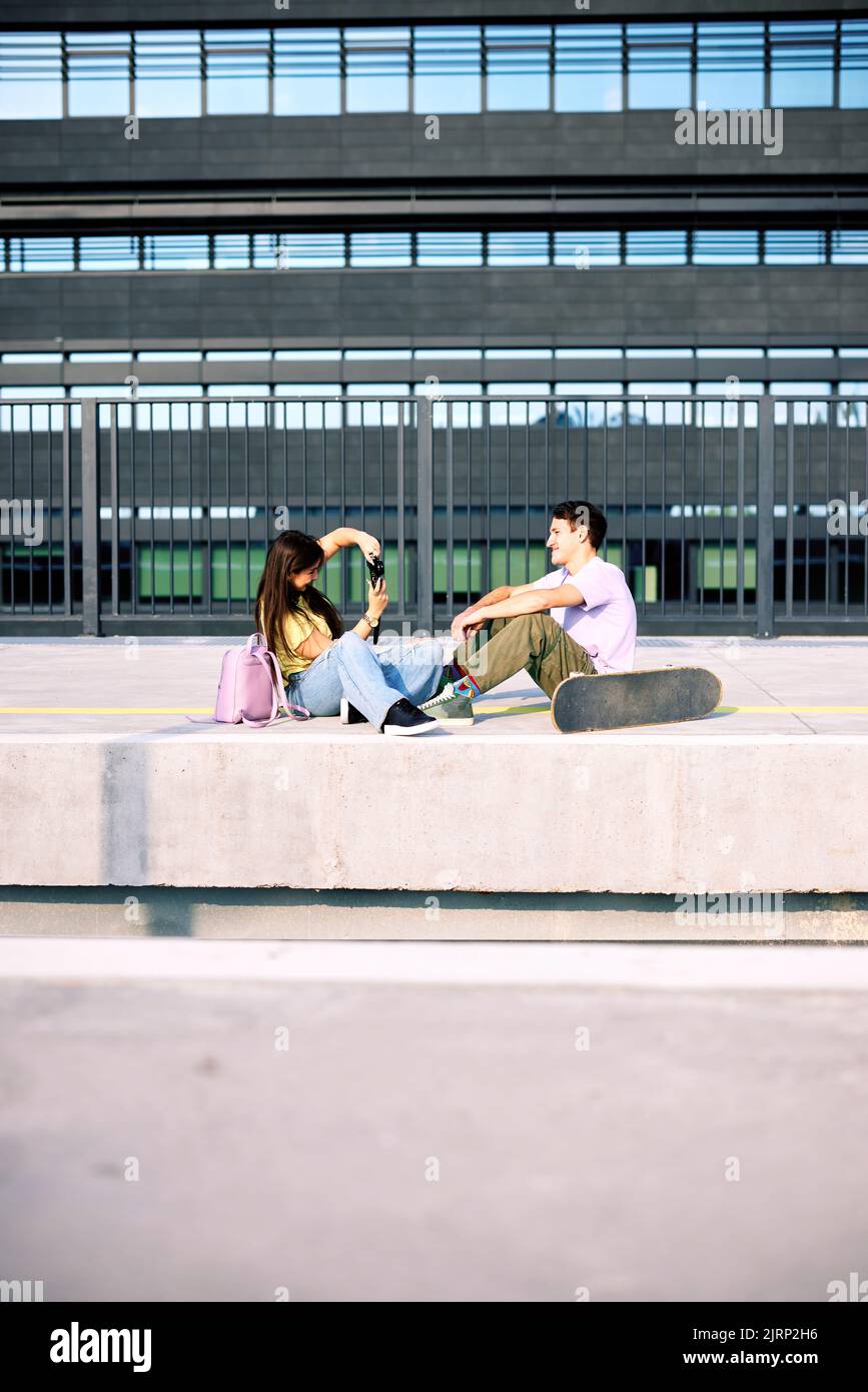 Teenage couple sitting on railroad station and taking photos Stock ...