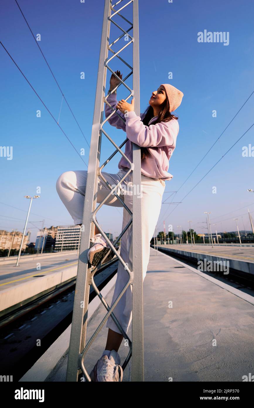 A rebellious girl doing dangerous stuff. A teenage girl climbing on