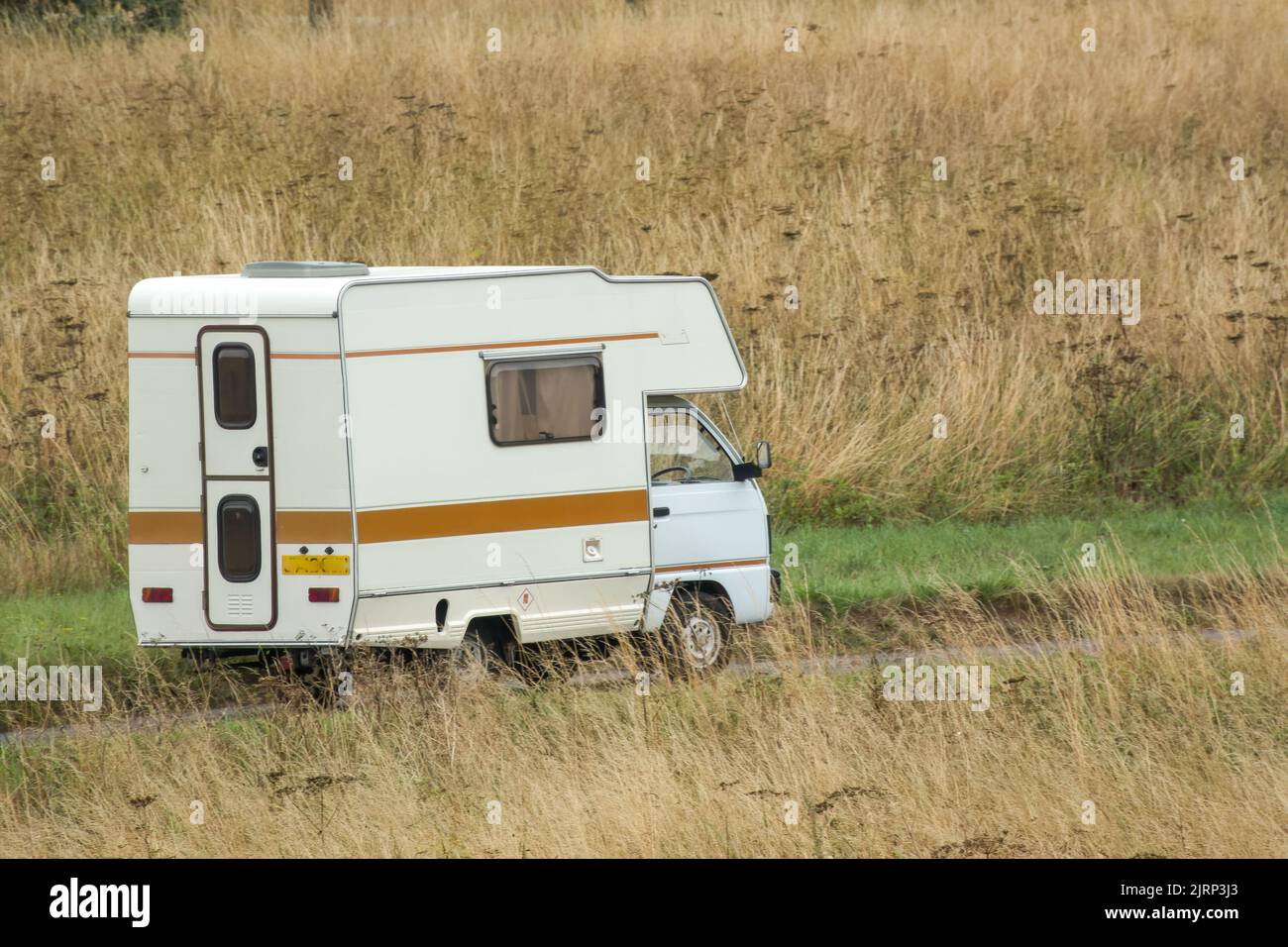 Vauxhall Bedford Rascal 1991 Nipper, 3 Berth, Overcab bed Campervan driving through parched summer countryside Stock Photo
