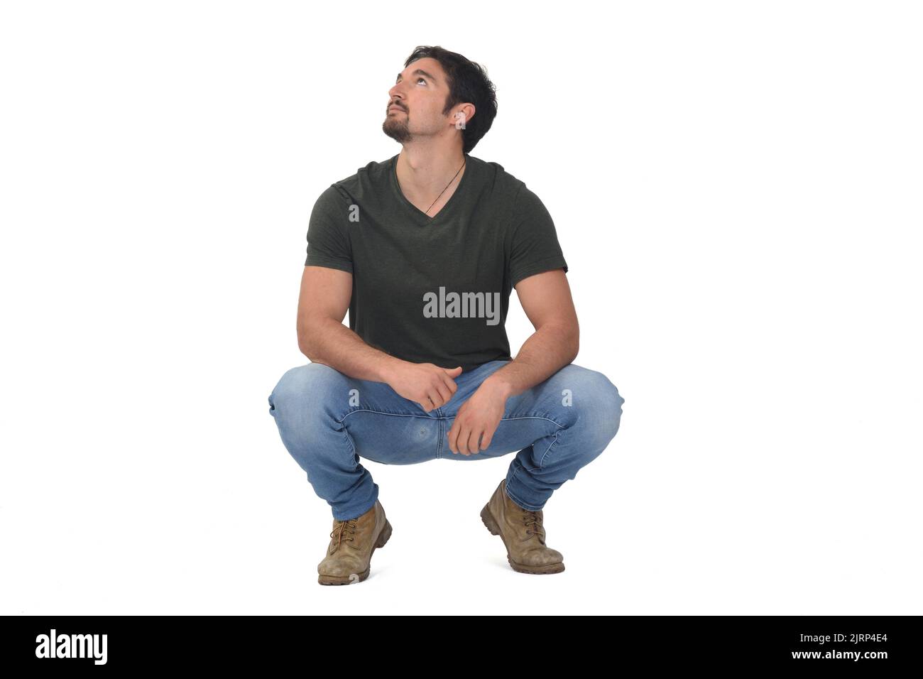 full portrait of a man squatting looking up on white background Stock