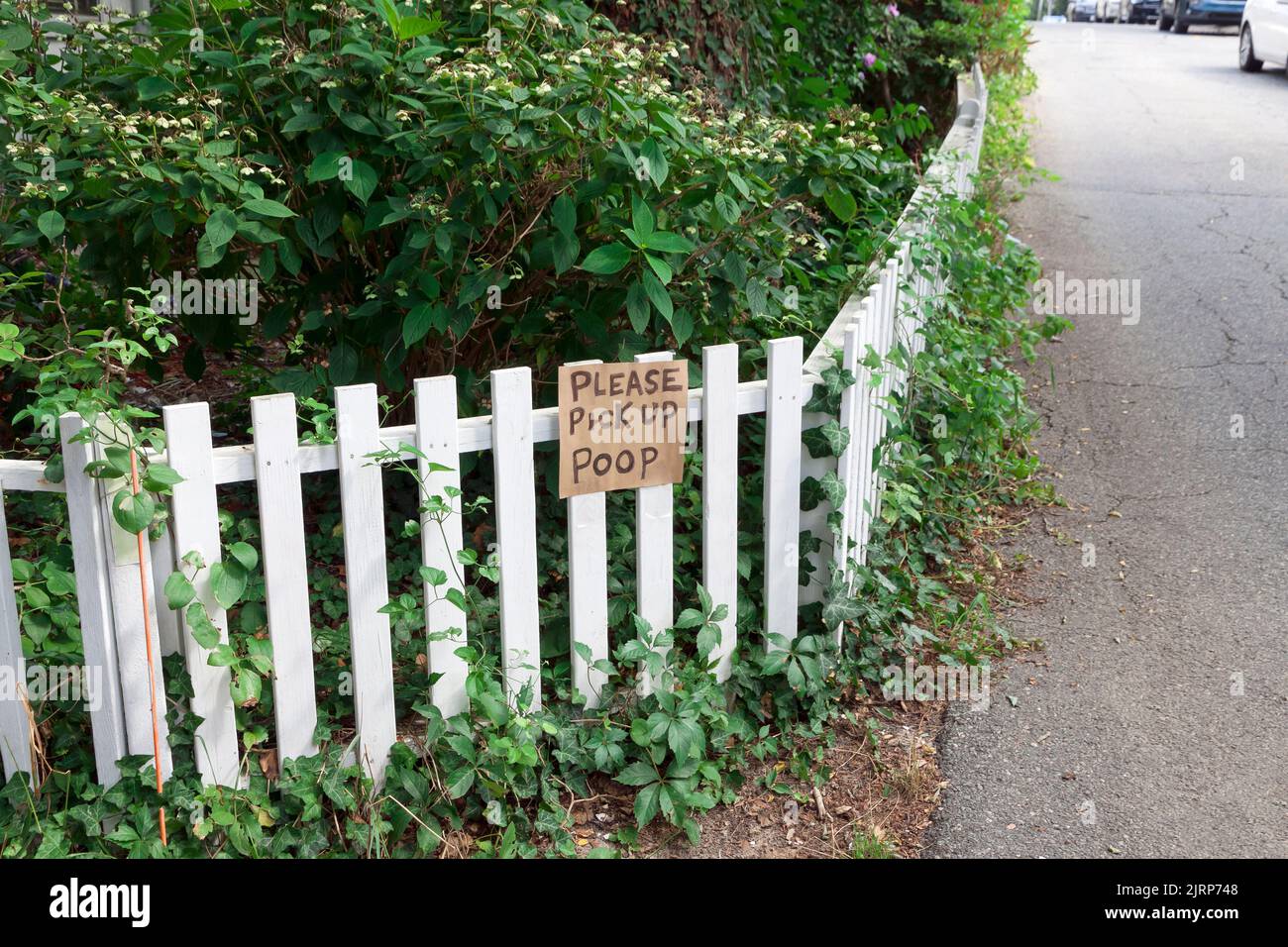 Sign on a yard fence saying 'Please Pick Up Poop' in Provincetown, Massachusetts, USA. Stock Photo