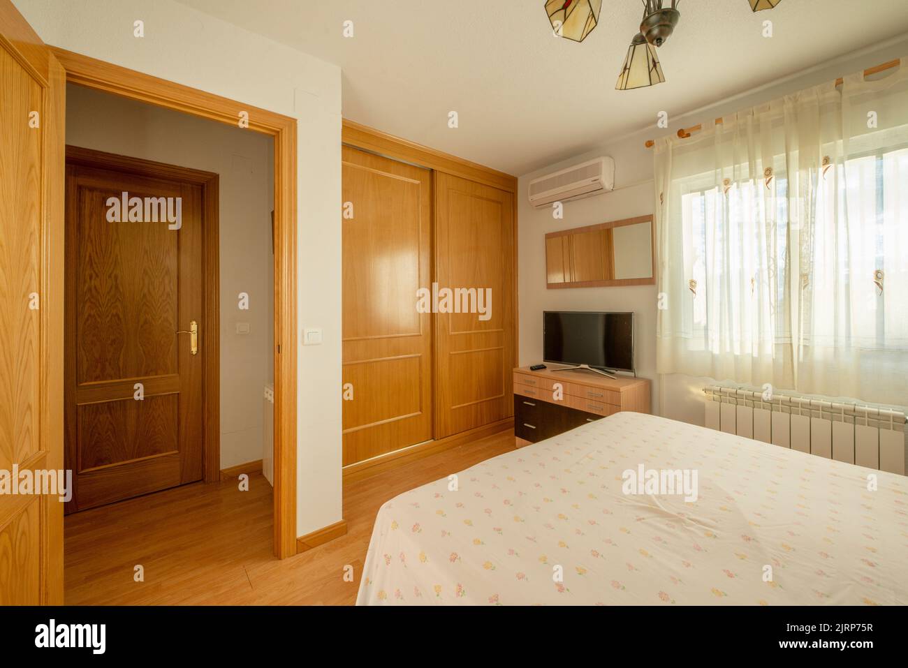 Bedroom with double bed, wardrobe with sliding oak doors, window with