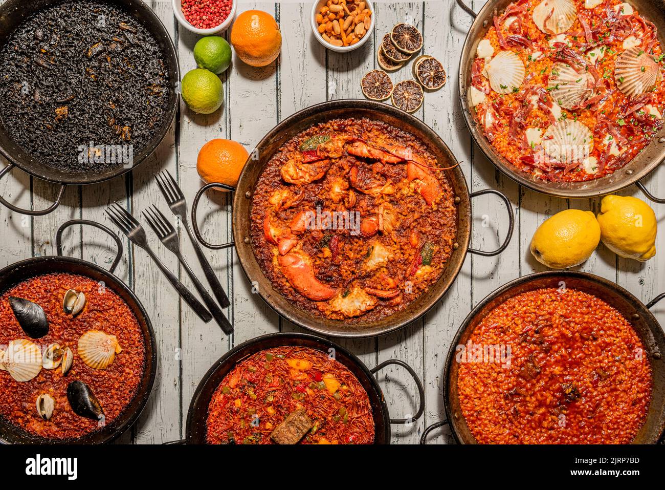 Set of varied paellas in their paella pans with lots of seafood, rice