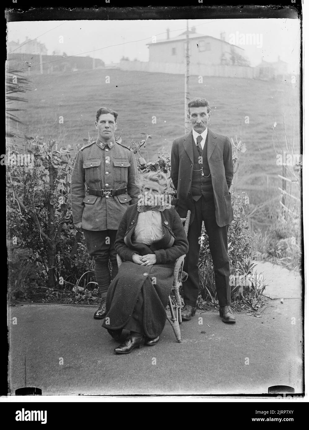 Group portrait seated woman and 2 men (1 wearing military uniform