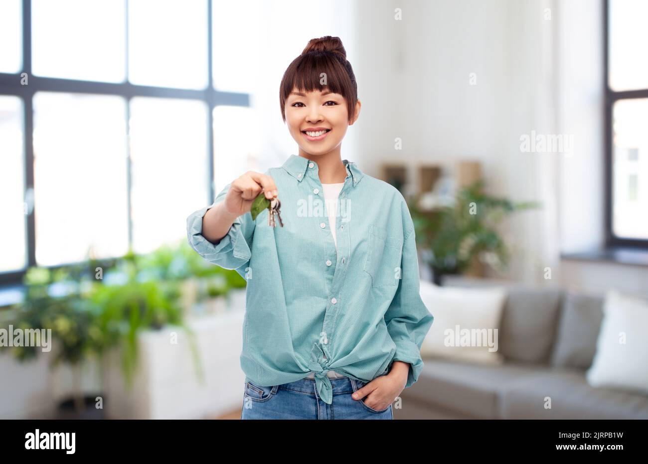 asian woman holding house keys with green leaf Stock Photo - Alamy