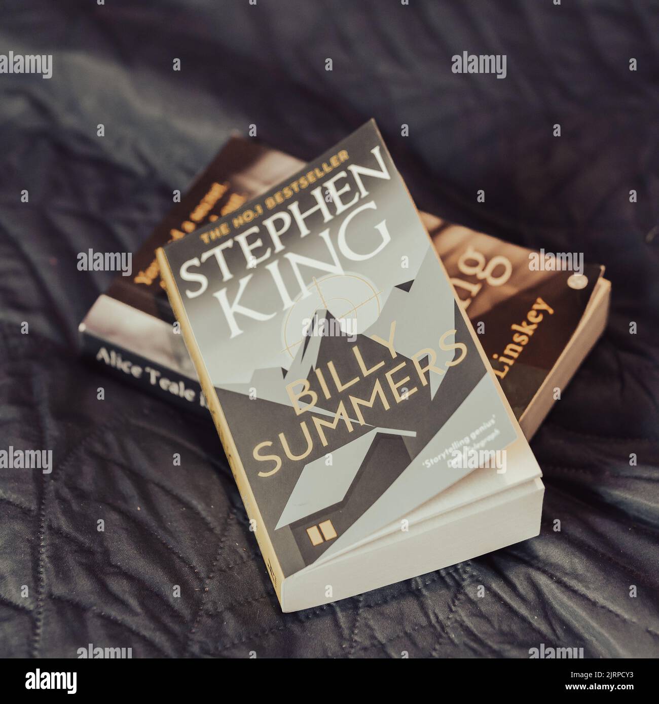 a-closeup-of-stephen-king-s-billy-summers-novel-laying-on-a-dark-gray