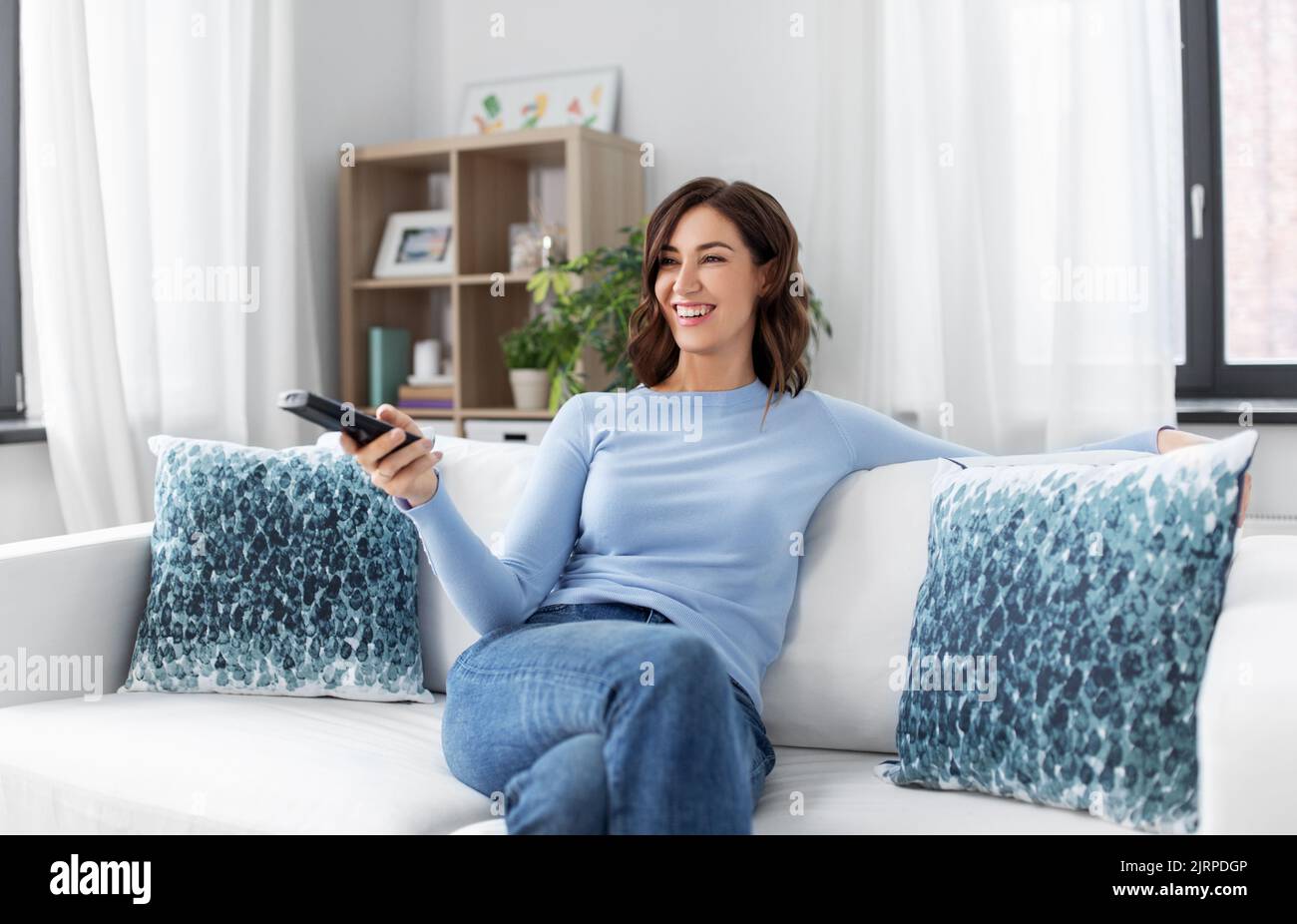 Happy woman smiling watching tv hi-res stock photography and images - Alamy