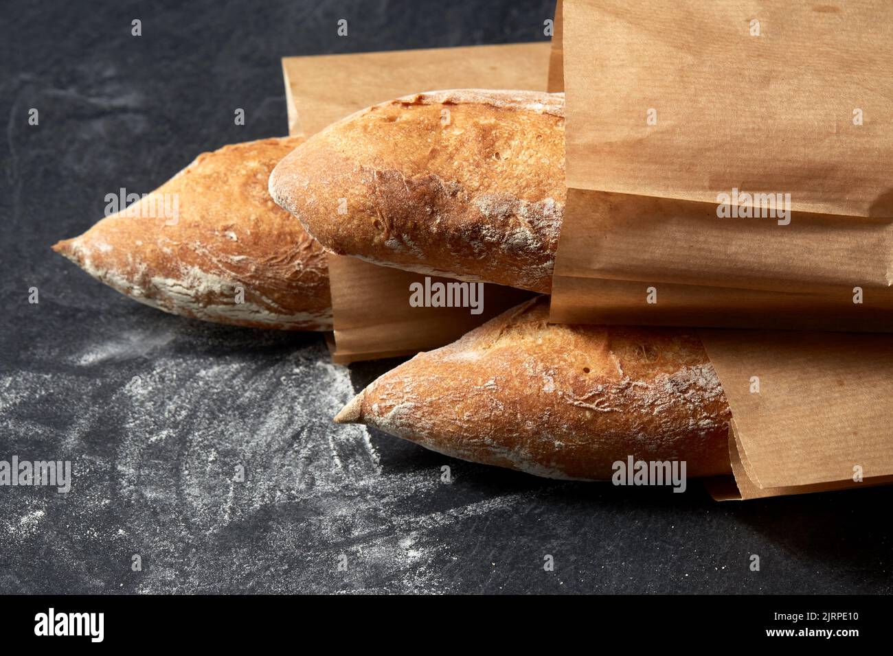 close up of baguette bread in paper bags on table Stock Photo Alamy