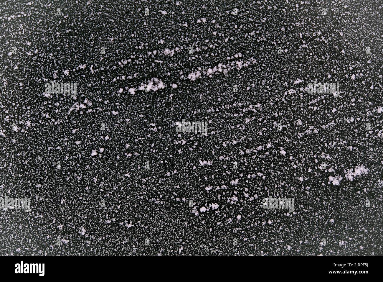 The black wall is covered with snow patterns. Frost on the painted wall ...
