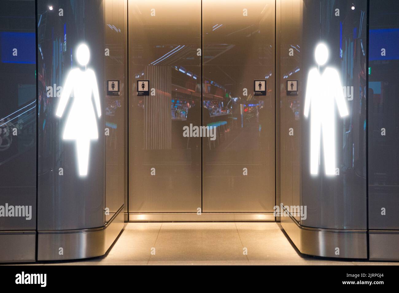 Ladies female loos (left) and male toilet / toilettes / lavatory / entrance doorway access (walk in without a door) Geneva airport, Switzerland. (131) Stock Photo