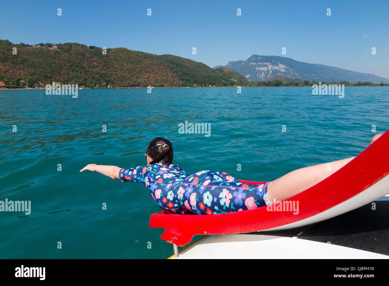 A family enjoy a trip on a pedalo, using the waterslide / water slide