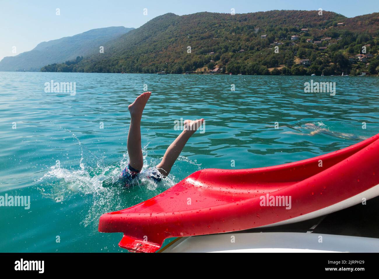 A family enjoy a trip on a pedalo, using the waterslide / water slide