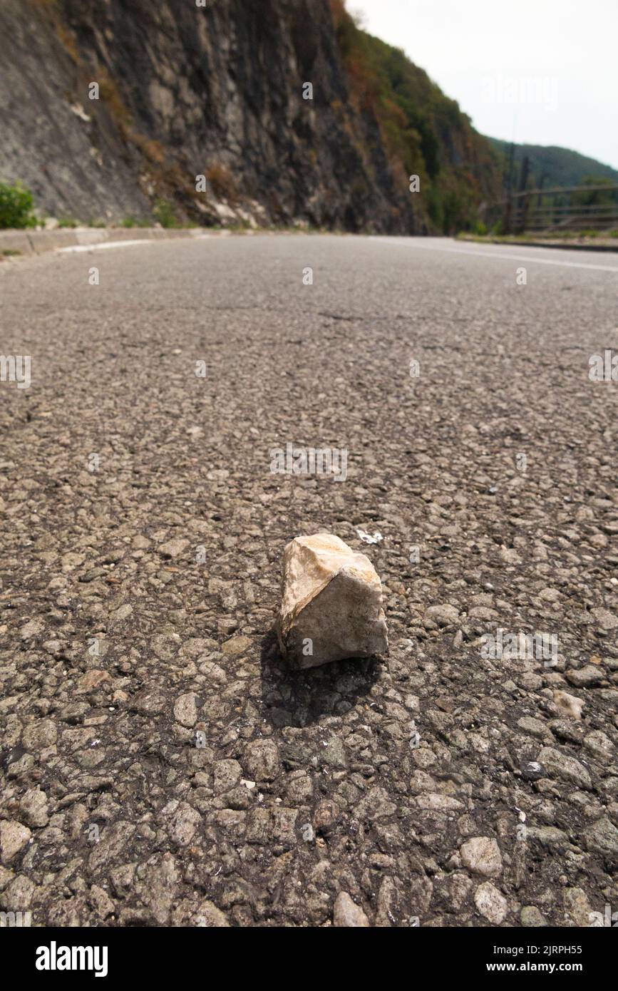 Fallen rock / cliff rocks on the road cause a hazard to car, drivers