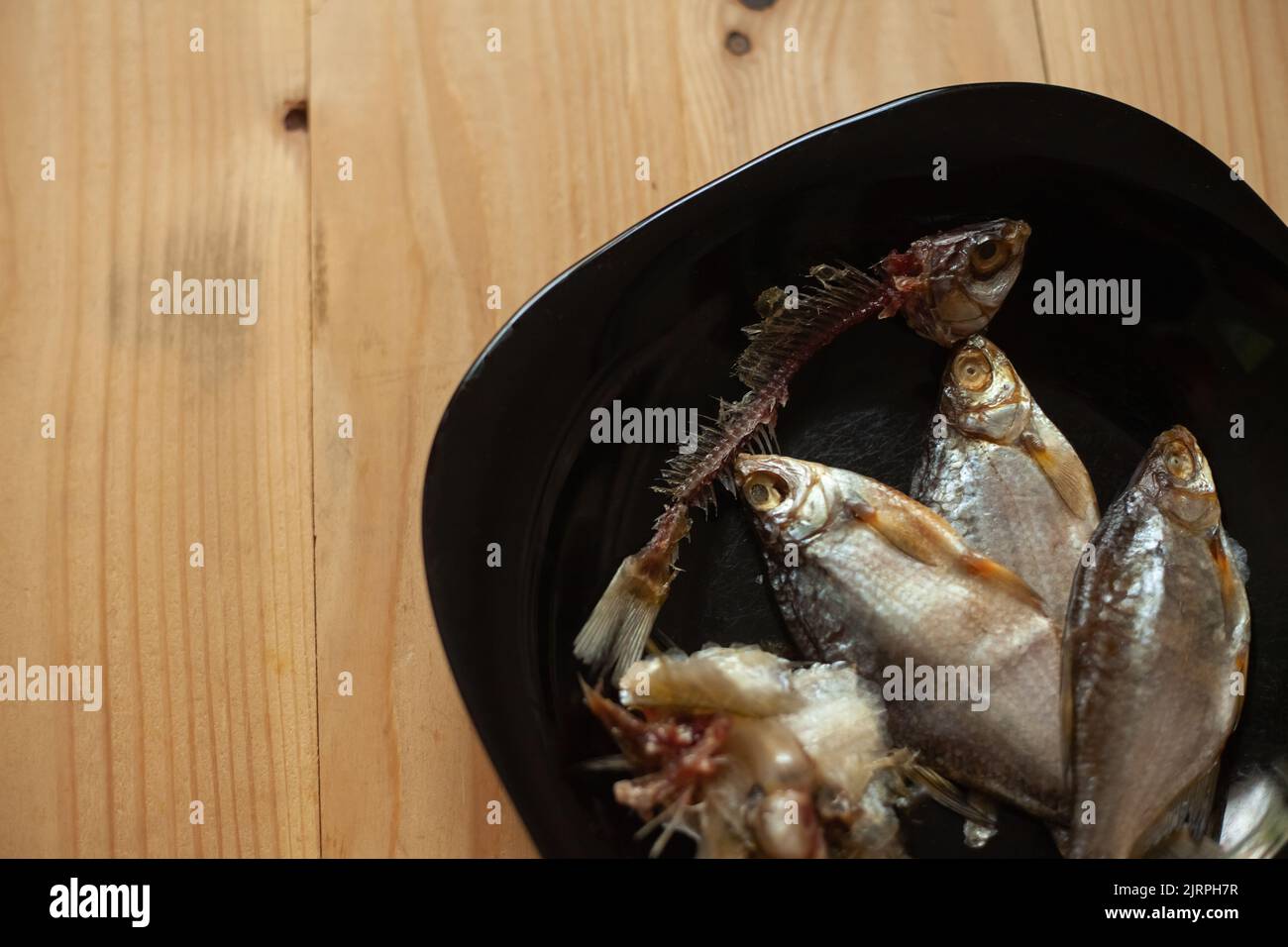 Cleaned dried fish, bones and spine with head in a plate. Fish skeleton