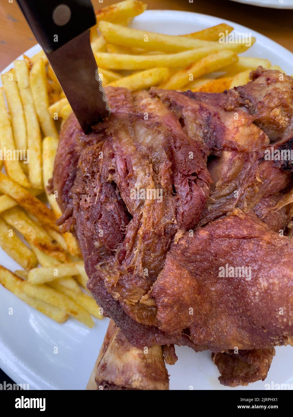 Pork knuckle with french fries. Stock Photo