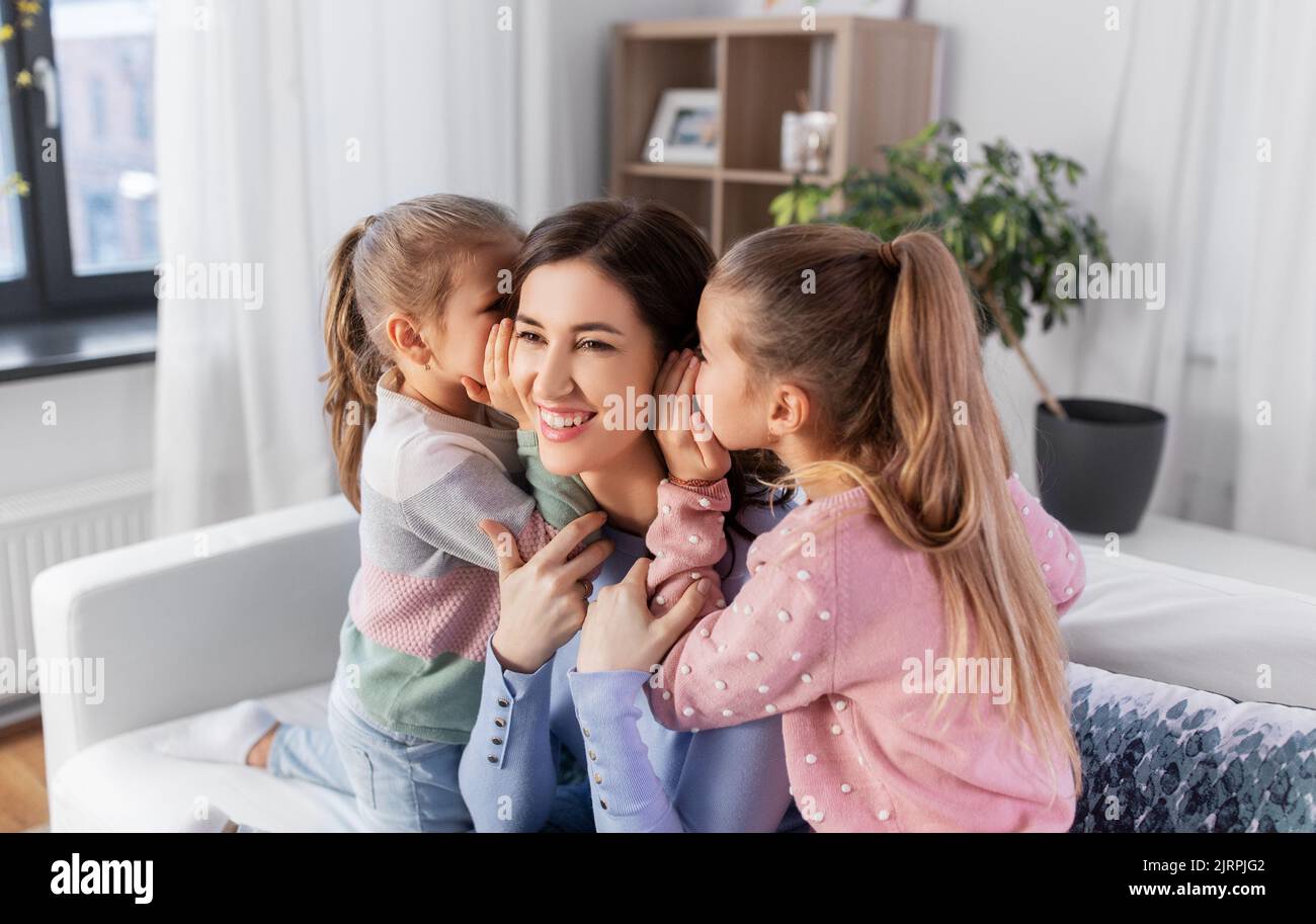 happy mother and daughters gossiping at home Stock Photo