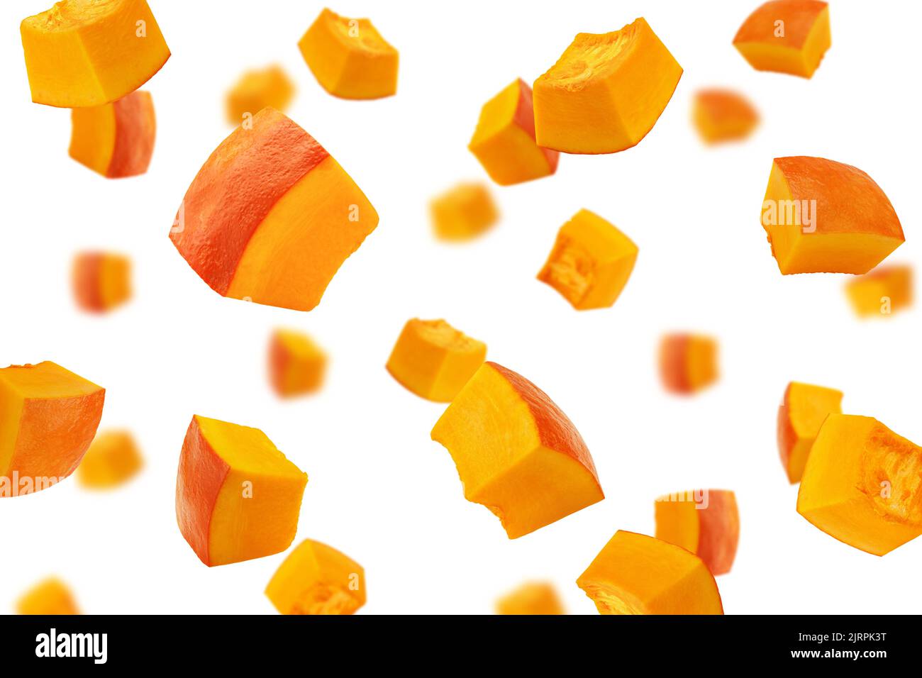 Falling piece of pumpkin, cubes, isolated on white background, selective focus Stock Photo