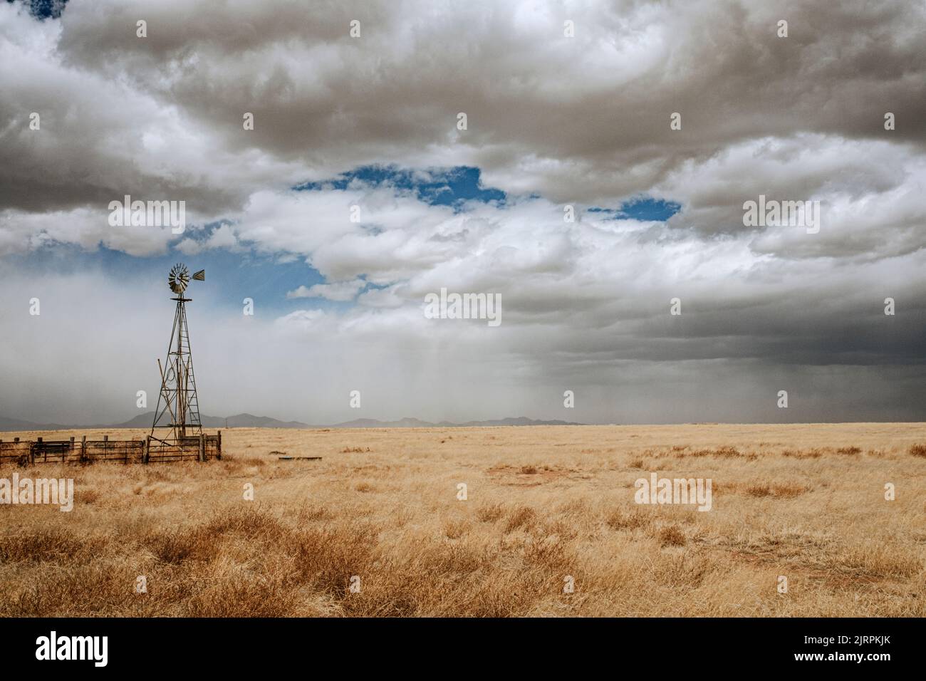 Agricultural wind mill and passing thunderstorm, tucumcari, New Mexico Stock Photo