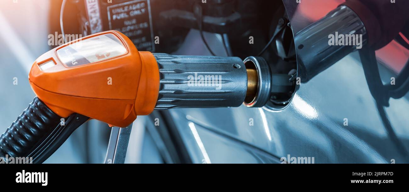 Close-up detail view of fuel autogas pump gun connected with noozle adapter to car tank to refill at car gas filling station. Refueling vehicle with Stock Photo