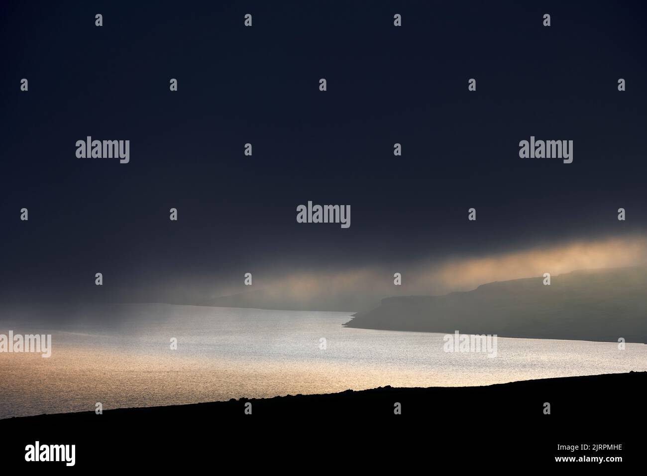 Cloudy sunset sky over sea and hills Stock Photo - Alamy