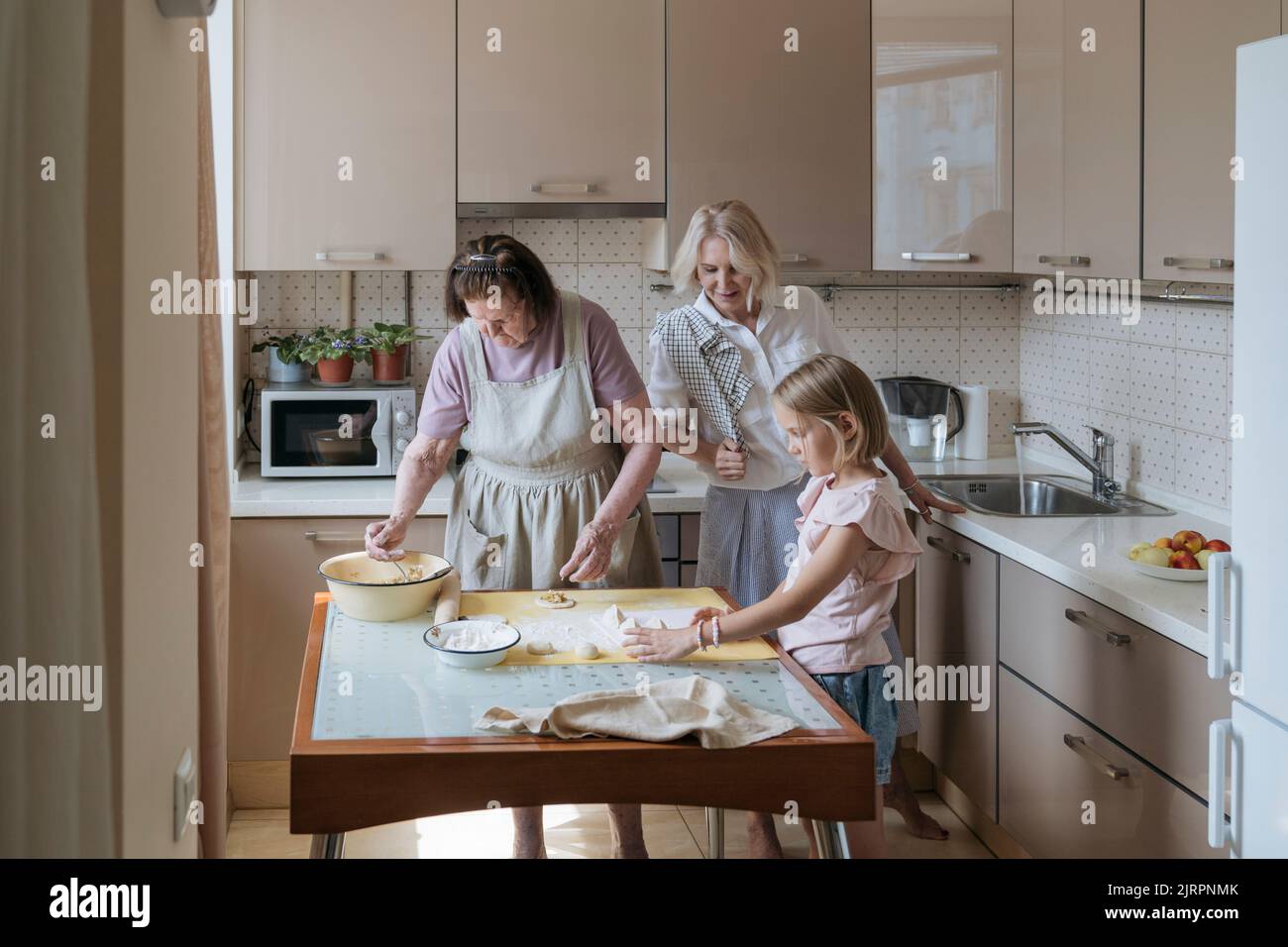 Three women in the kitchen are cooking homemade pies Stock Photo Alamy