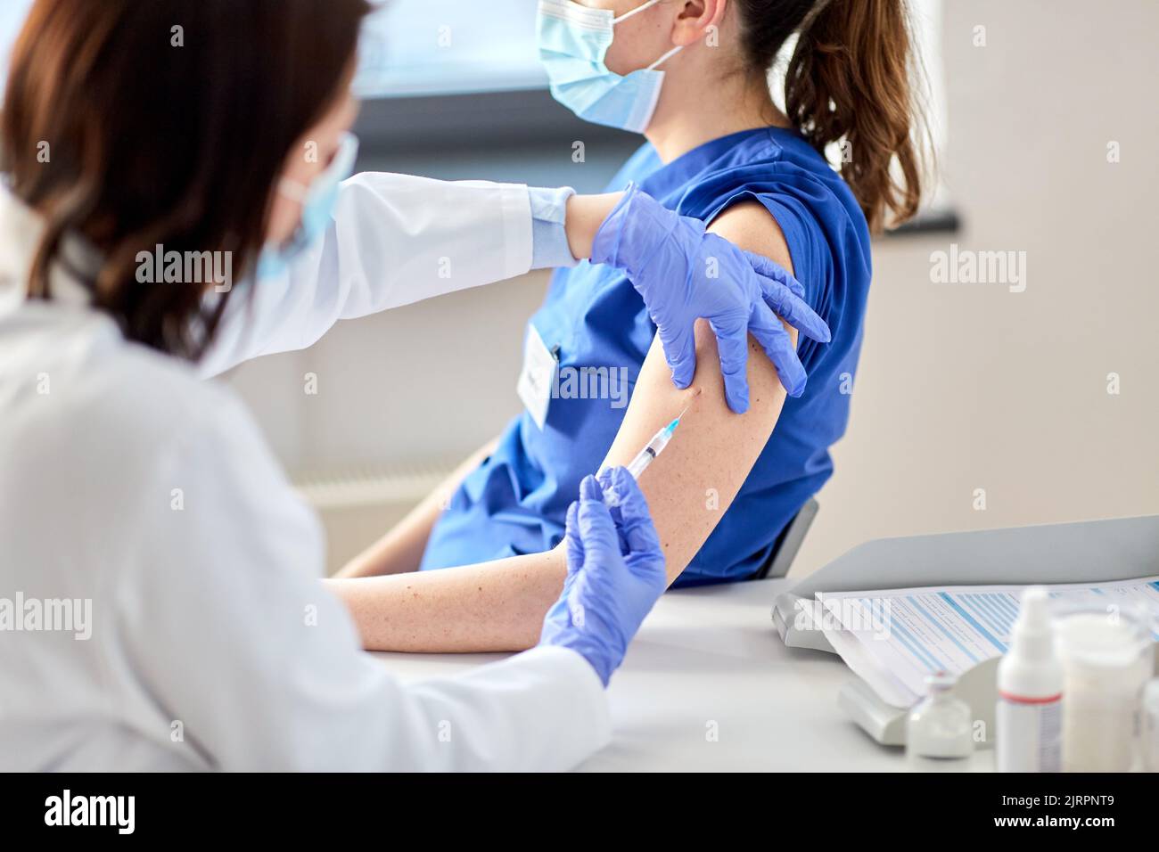 doctor with syringe vaccinating medical worker Stock Photo - Alamy