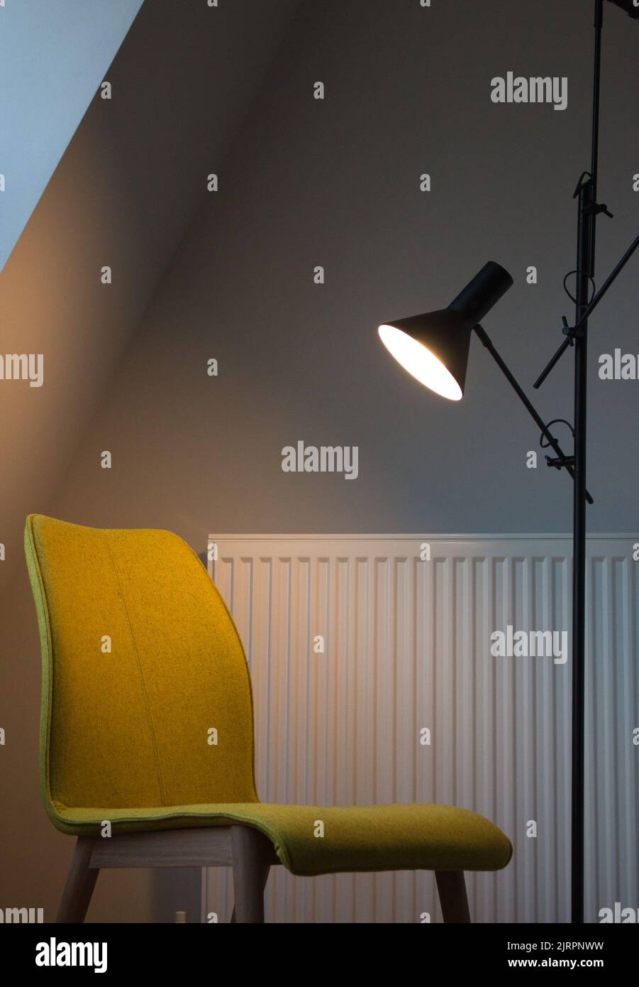 Yellow chair and radiator in lamp spotlight Stock Photo