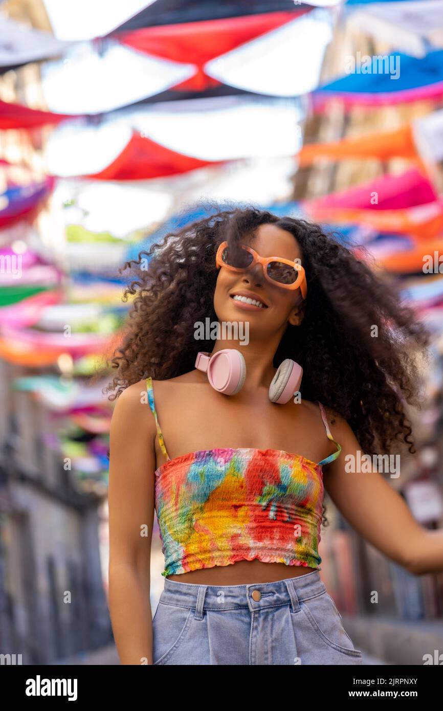 girl with hair walking around the city with her headphones Stock Photo