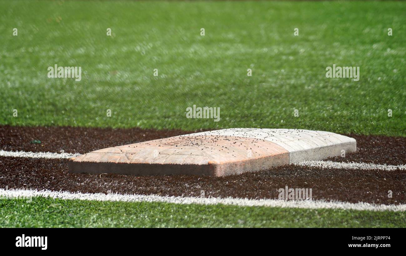 Ground level view of first base and safety bag on a turf baseball and