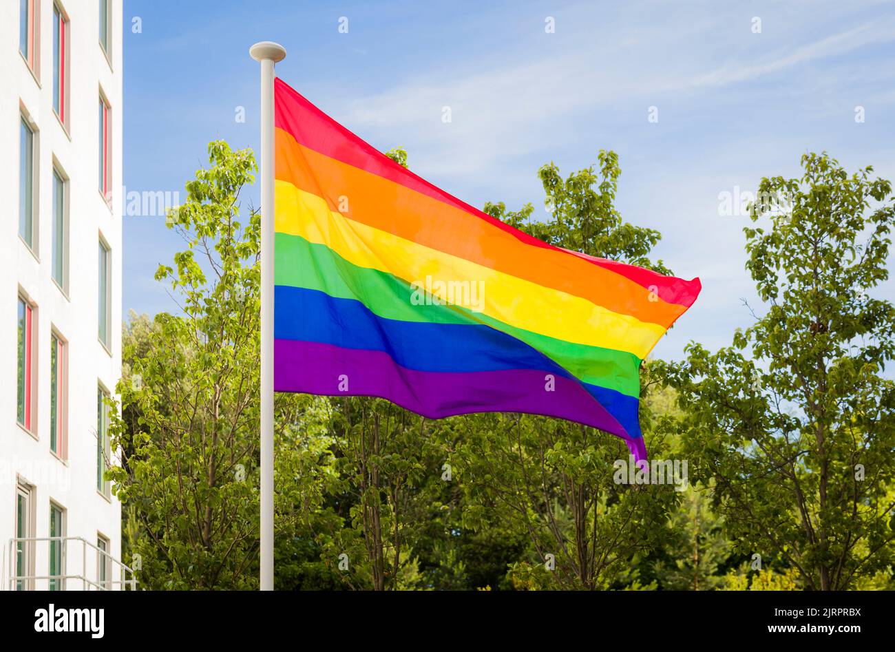 Gay pride flag (rainbow flag), a symbol of LBGT diversity, flying on a flagpole in Bournemouth, UK Stock Photo
