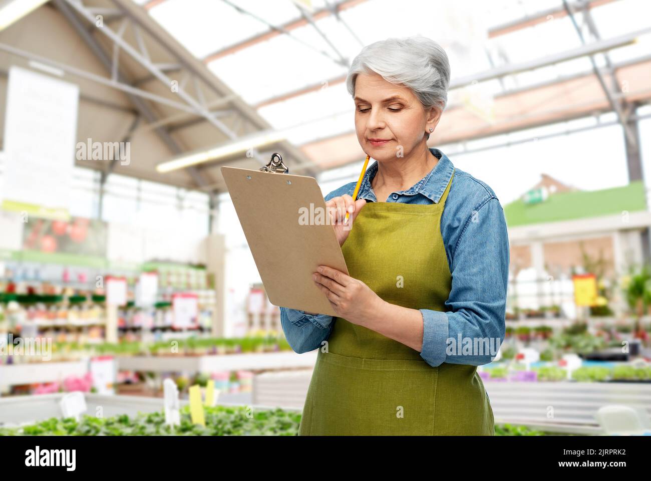 senior woman with clipboard at garden store Stock Photo