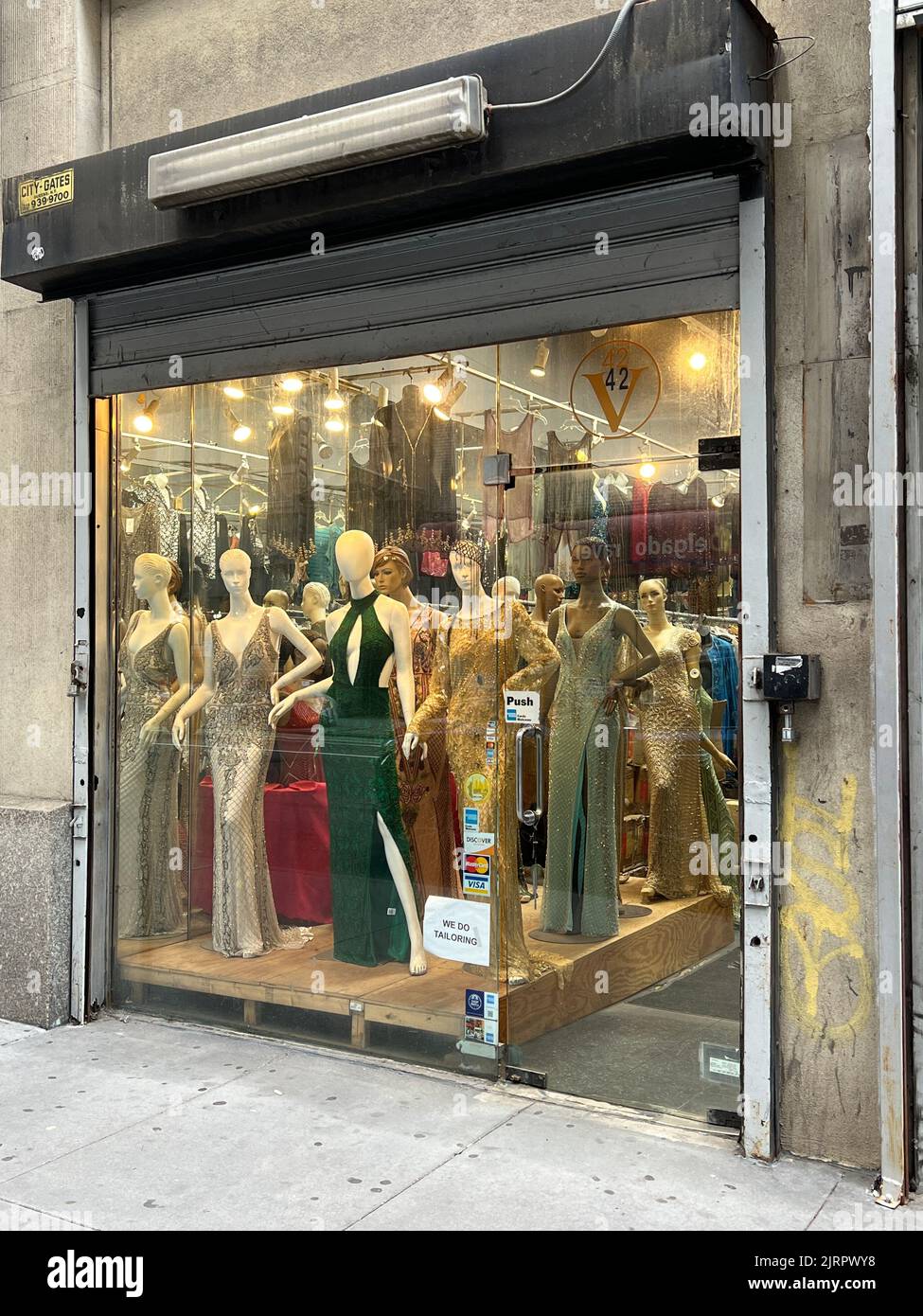 Evening dresses on display in a window in the Garment District on the west side of Manhattan, New York City. Stock Photo
