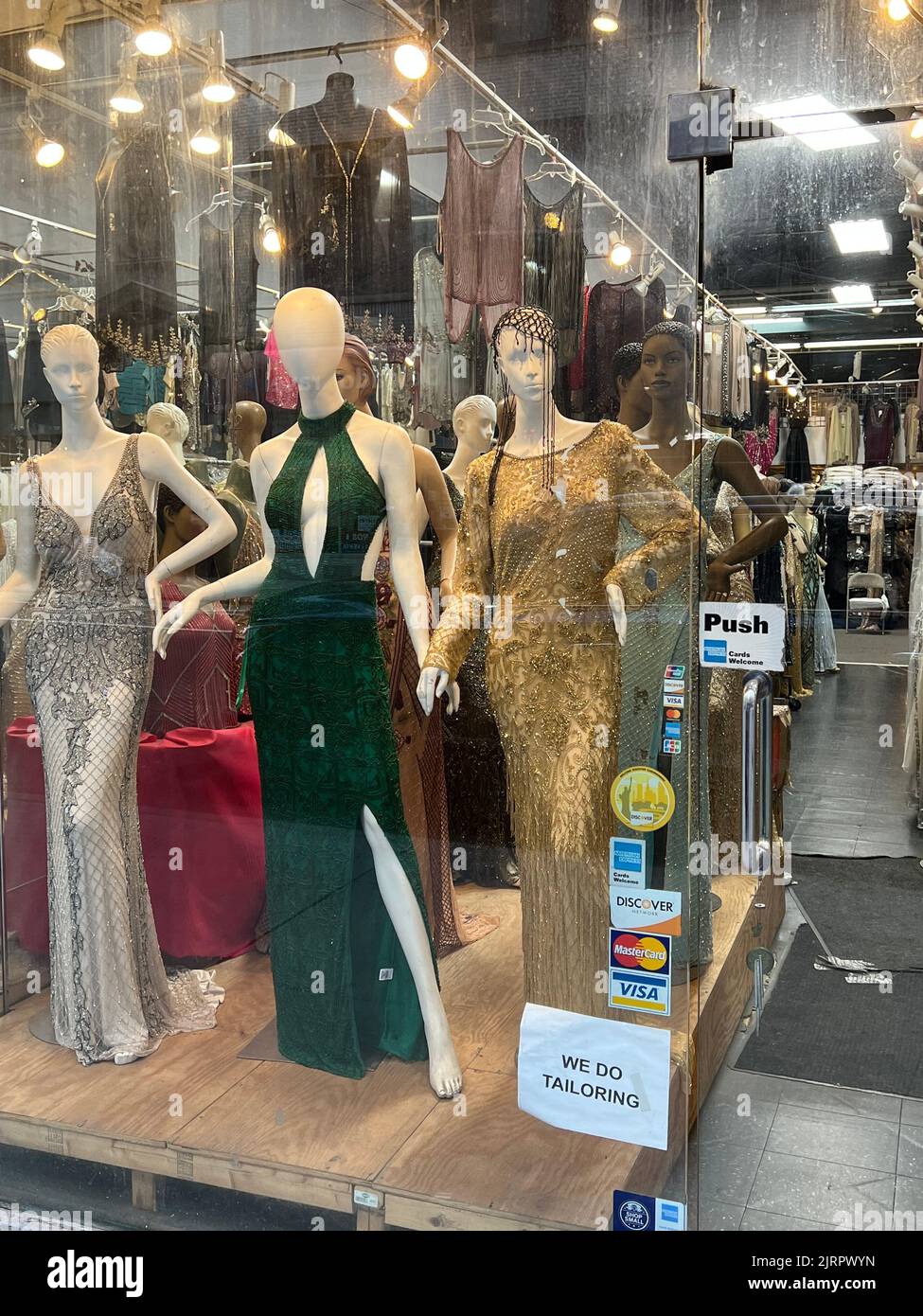 Evening dresses on display in a window in the Garment District on the west side of Manhattan, New York City. Stock Photo