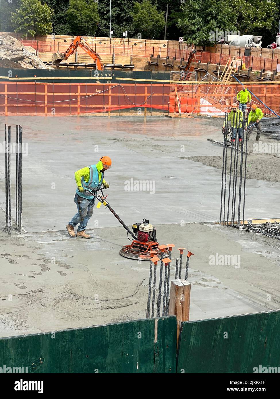 Cement workers putting in a huge cement floor above the basement garage