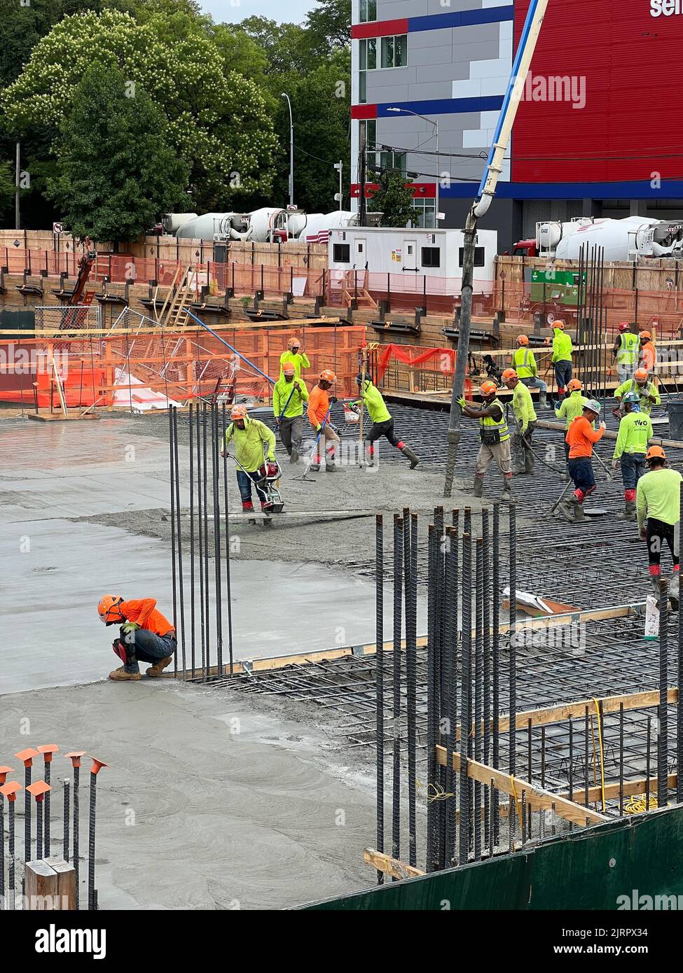 Cement workers putting in a huge cement floor above the basement garage