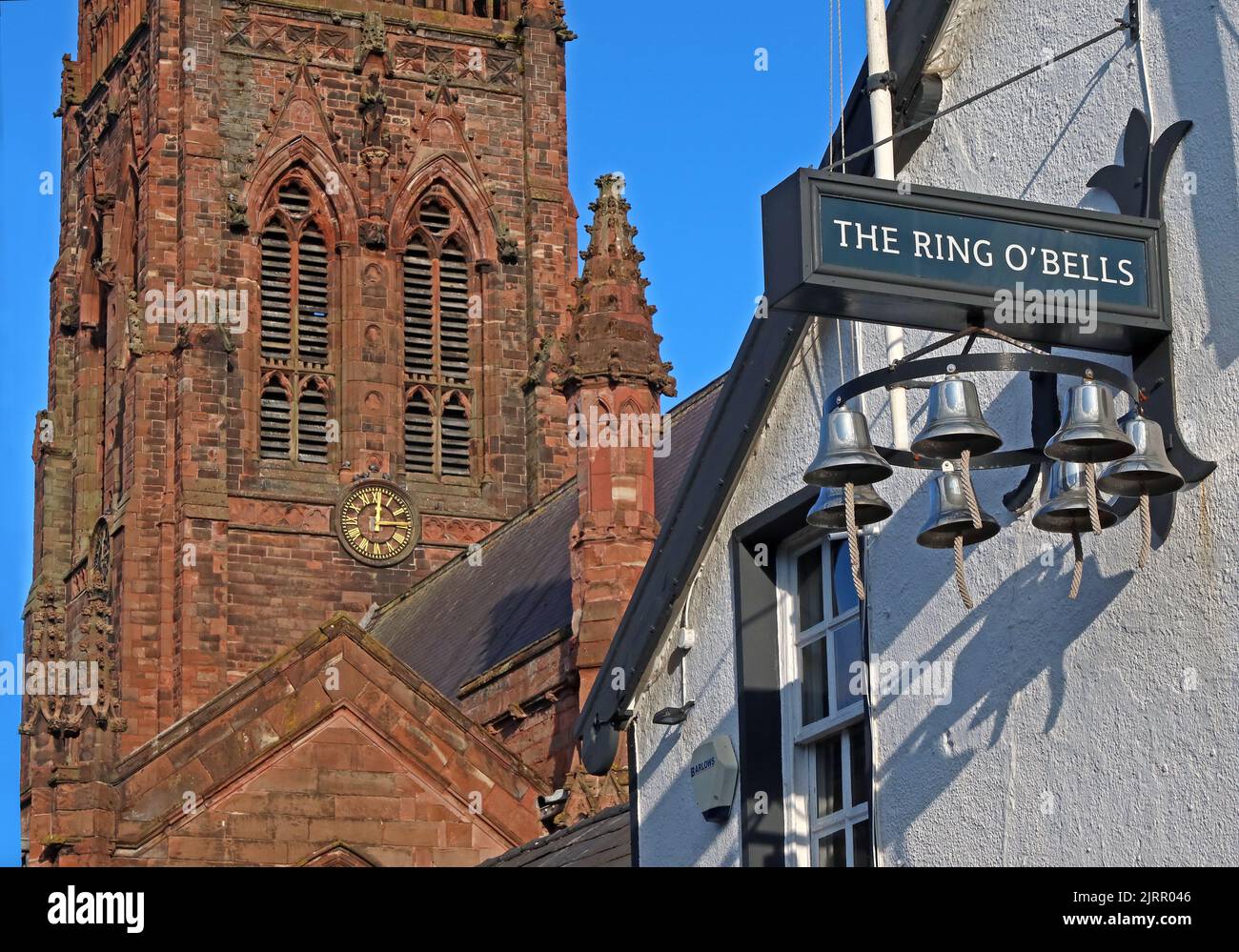Ring Of Bells pub with St Elphins church clock behind, 131 Church Street, Warrington, Cheshire, England, UK, WA1 2TL Stock Photo