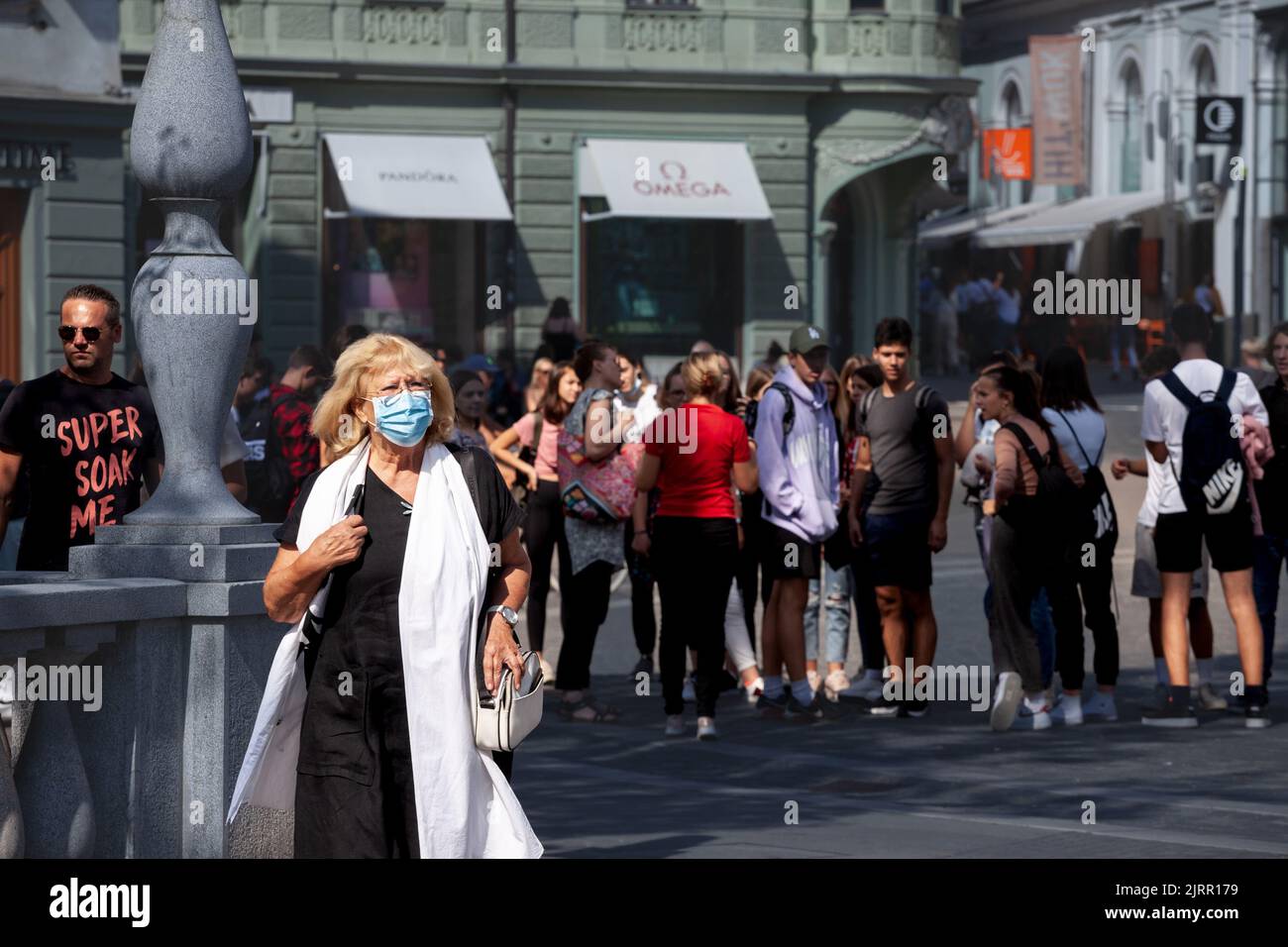 Picture of a white caucasian senior woman in Ljubljana, capital city of Slovenia while wearing a respiratory face mask during the coronavirus health c Stock Photo