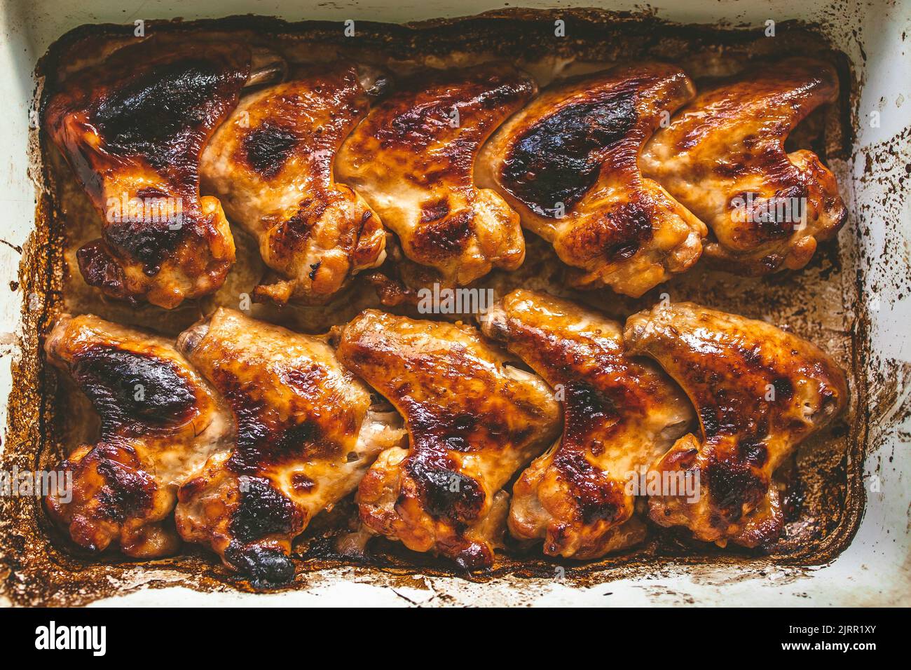 appetizing baked chicken wings in a baking sheet, top view. Stock Photo