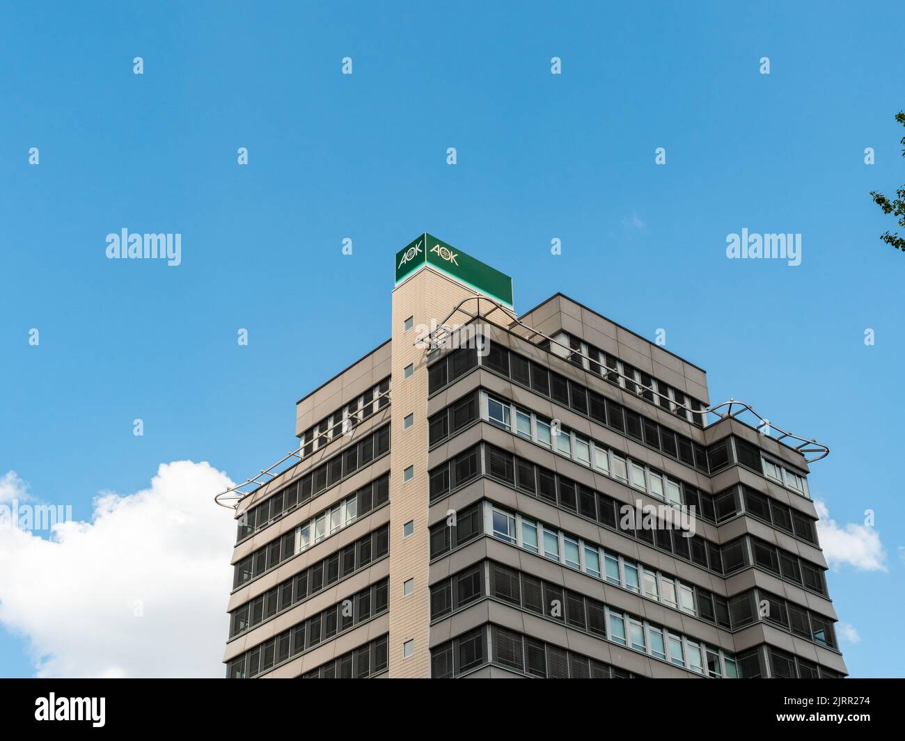 AOK German health maintenance organisation office building in the city. Public health care service. The logo sign is on top of the house exterior. Stock Photo