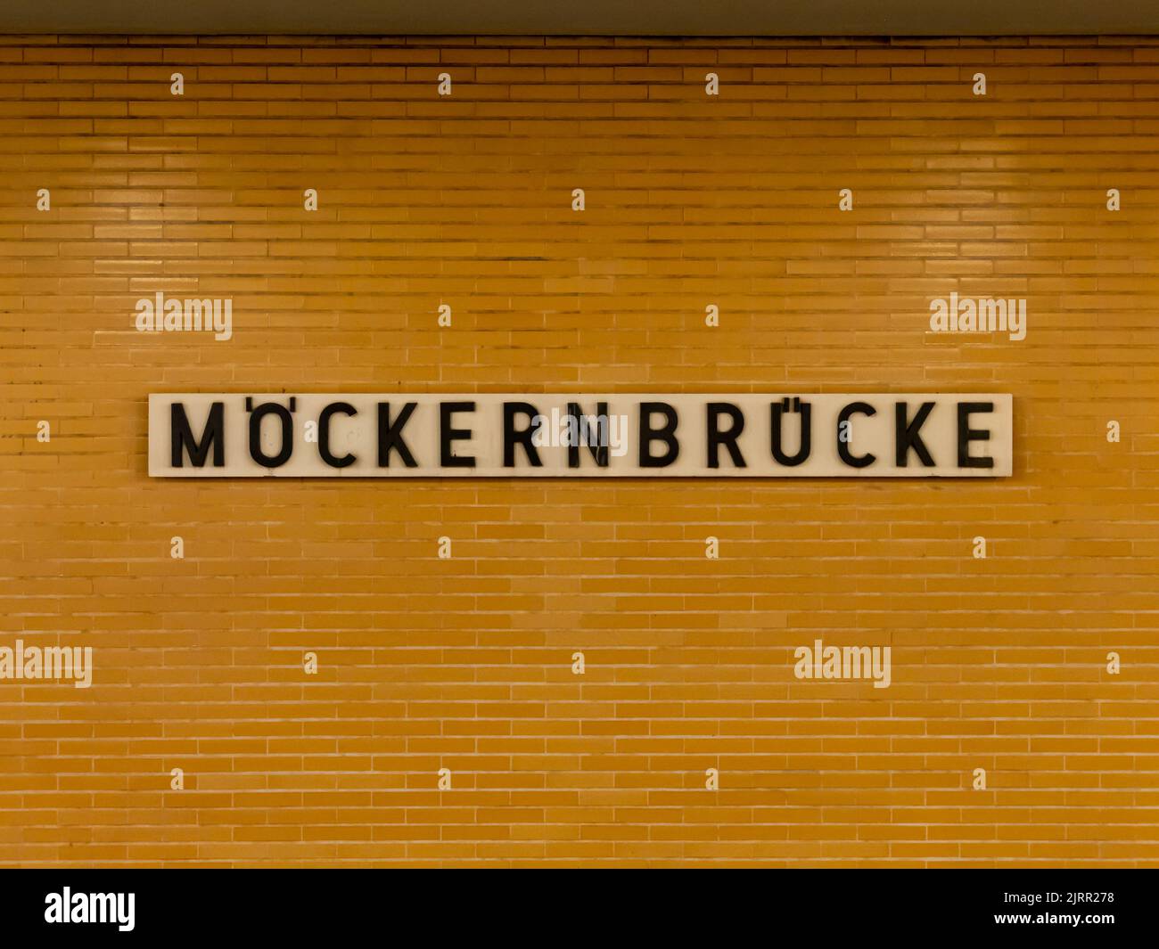 Möckernbrücke U-Bahn station in Berlin city. Old design with a yellow tiled wall exterior. Black letters on a white board. Subway station name board. Stock Photo