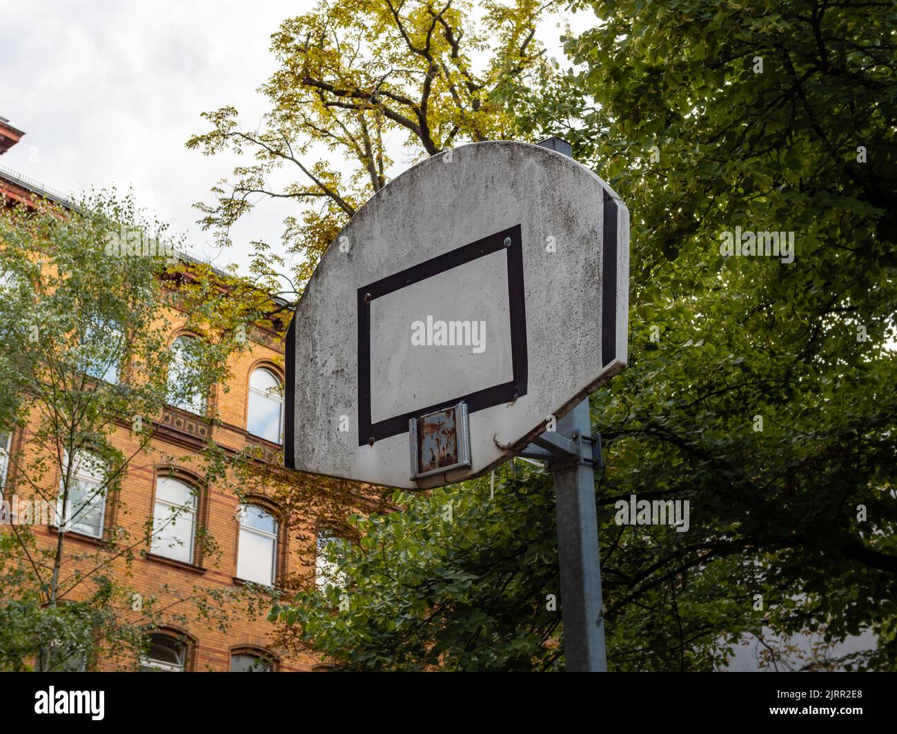 Old abandoned basketball court with a broken basket. The backboard is