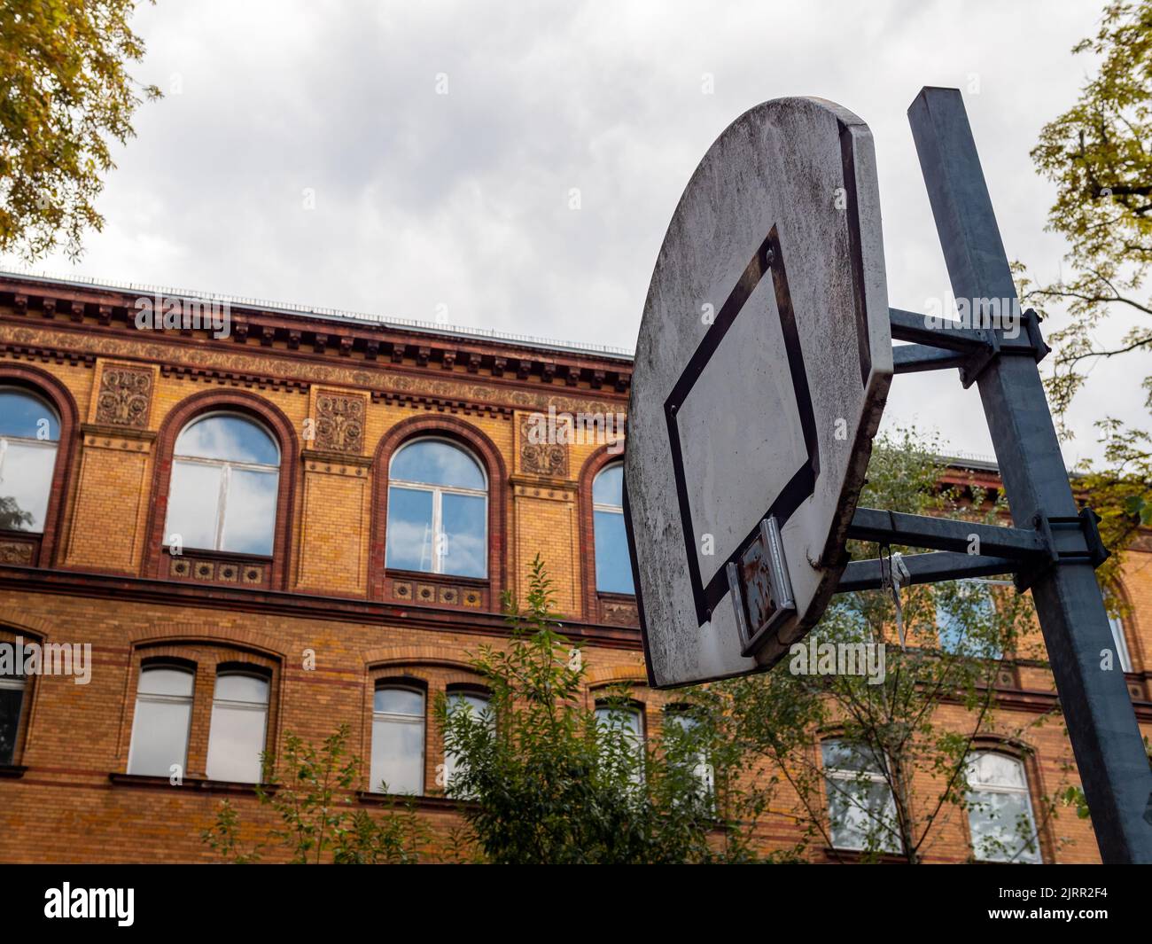 Old abandoned basketball court with a broken basket. The backboard is