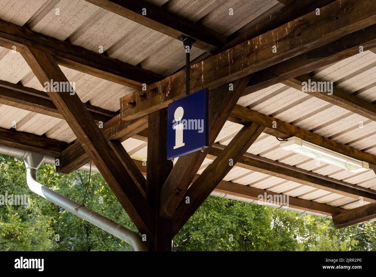 Information sign at a train station. Symbol to get help when travelling with public transportation. Letter i on a blue metal plate. Info service point Stock Photo