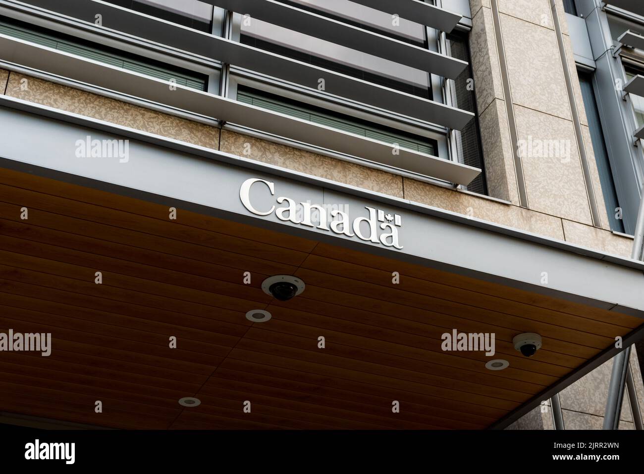 Canada lettering on the building entrance of the Canadian Embassy at the Potsdamer Platz in Berlin. Silver logo with a small Canadian flag. Stock Photo
