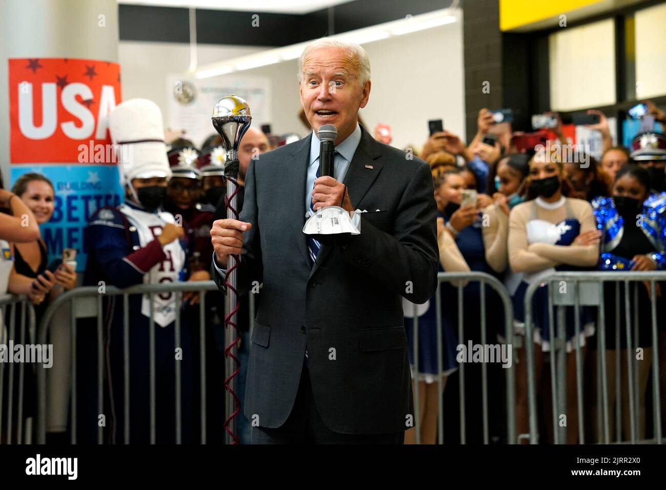 US President Joe Biden holds a marching band leader baton as he
